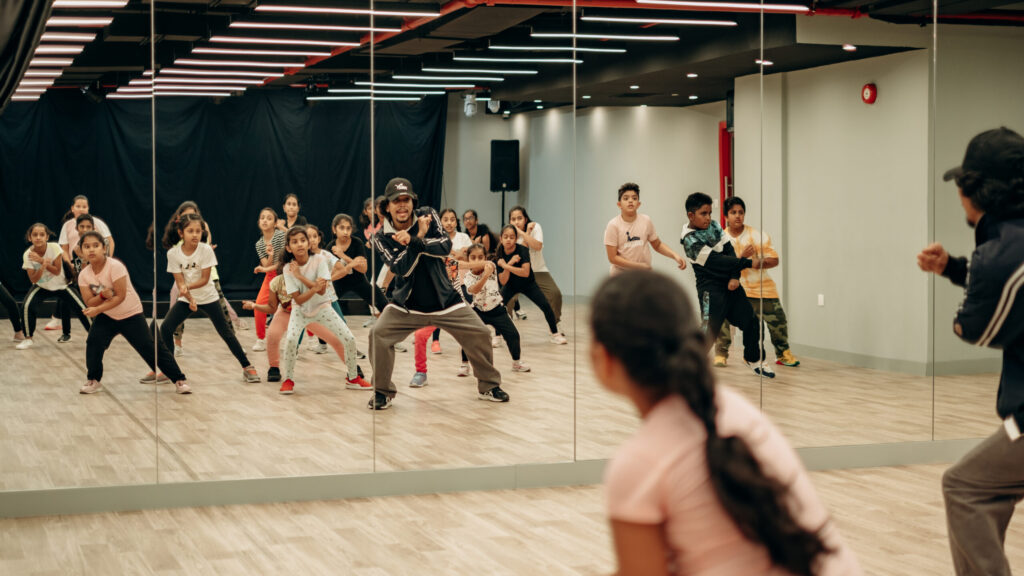Dance instructor and students practicing routine together in the Dee Studio studio room